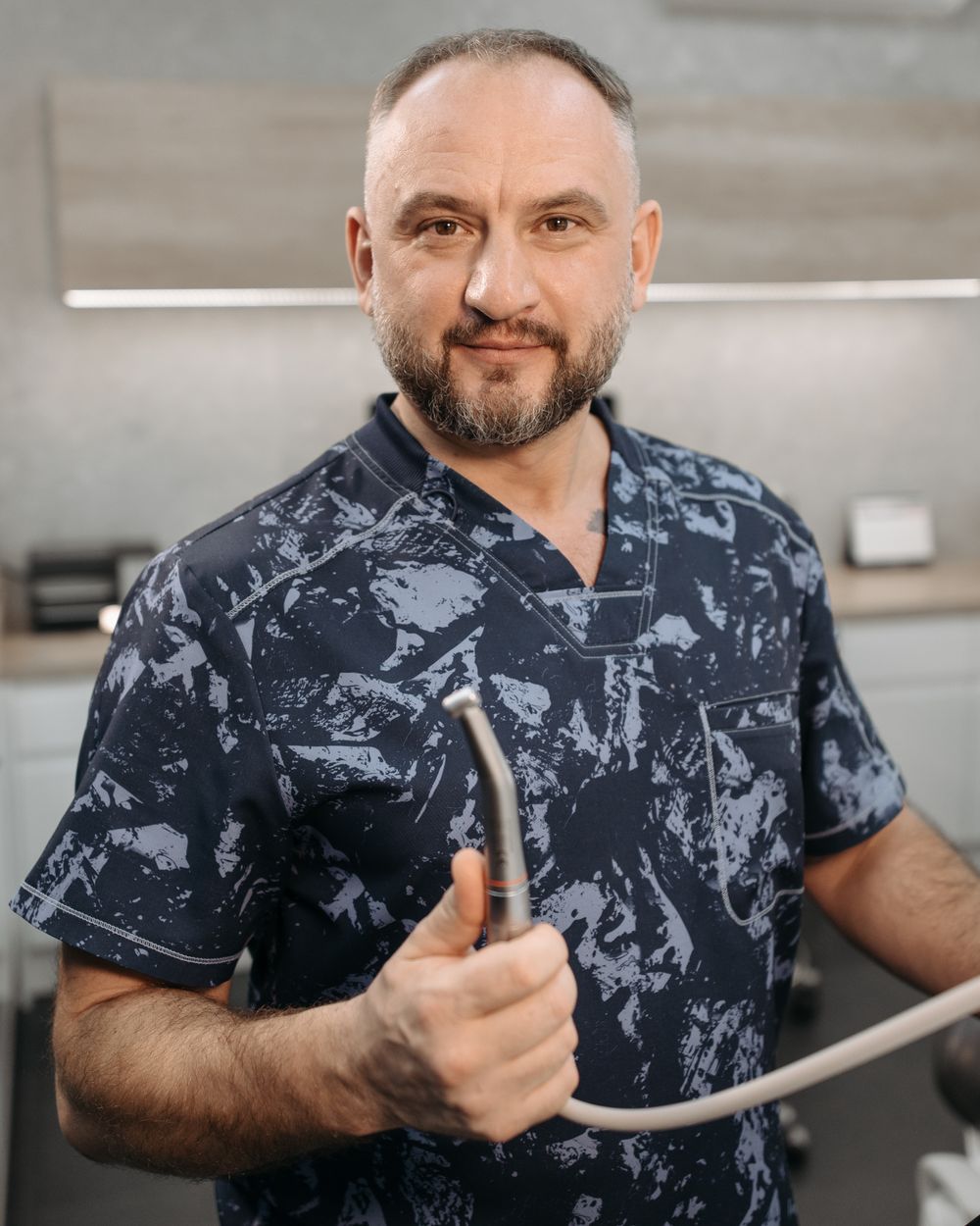 Male dentist smiling in scrubs